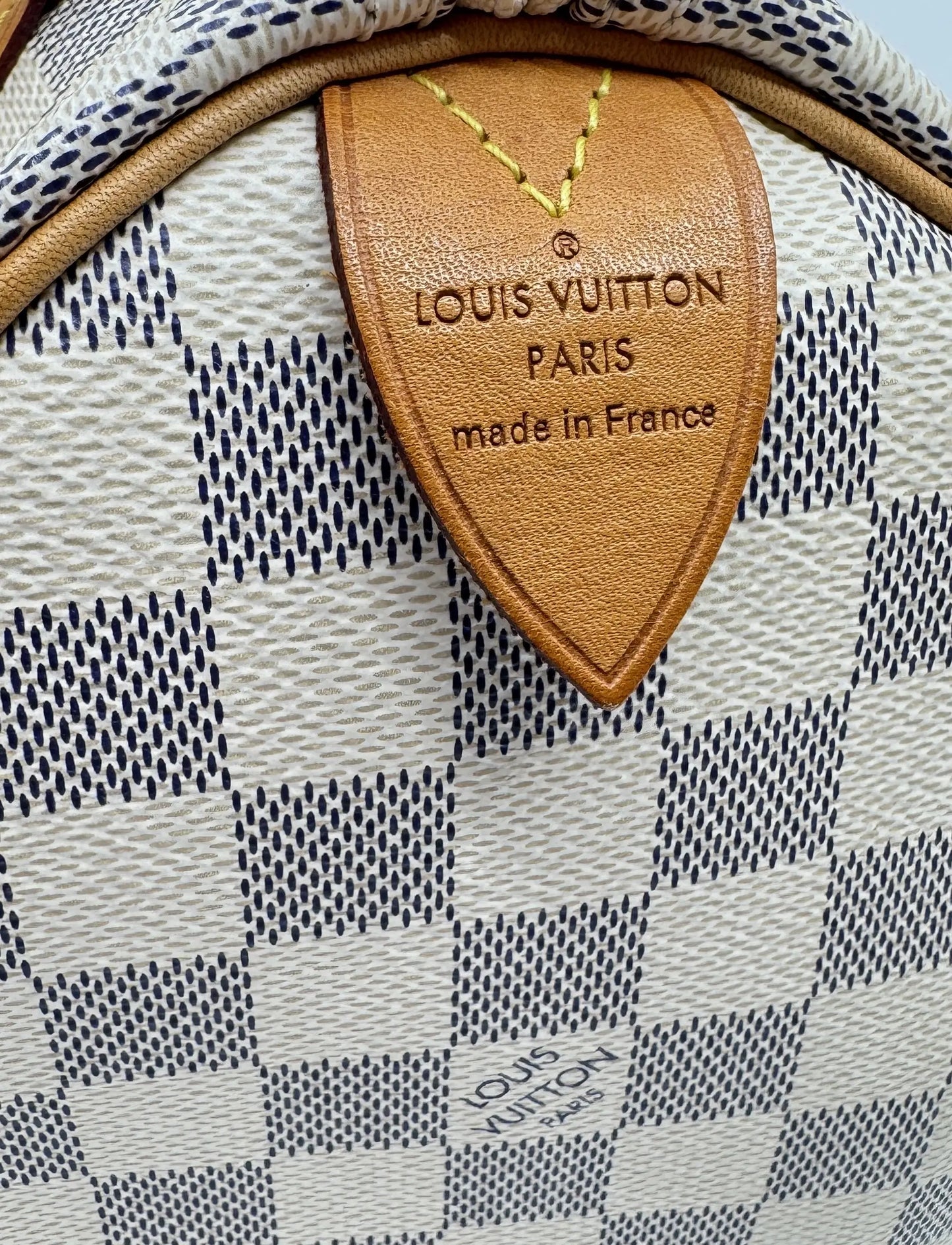 Detail-of-the-Louis-Vuitton-Speedy-25-Damier-Azur-label-with-registered-trademark-made-in-France-and-year-of-manufacture.