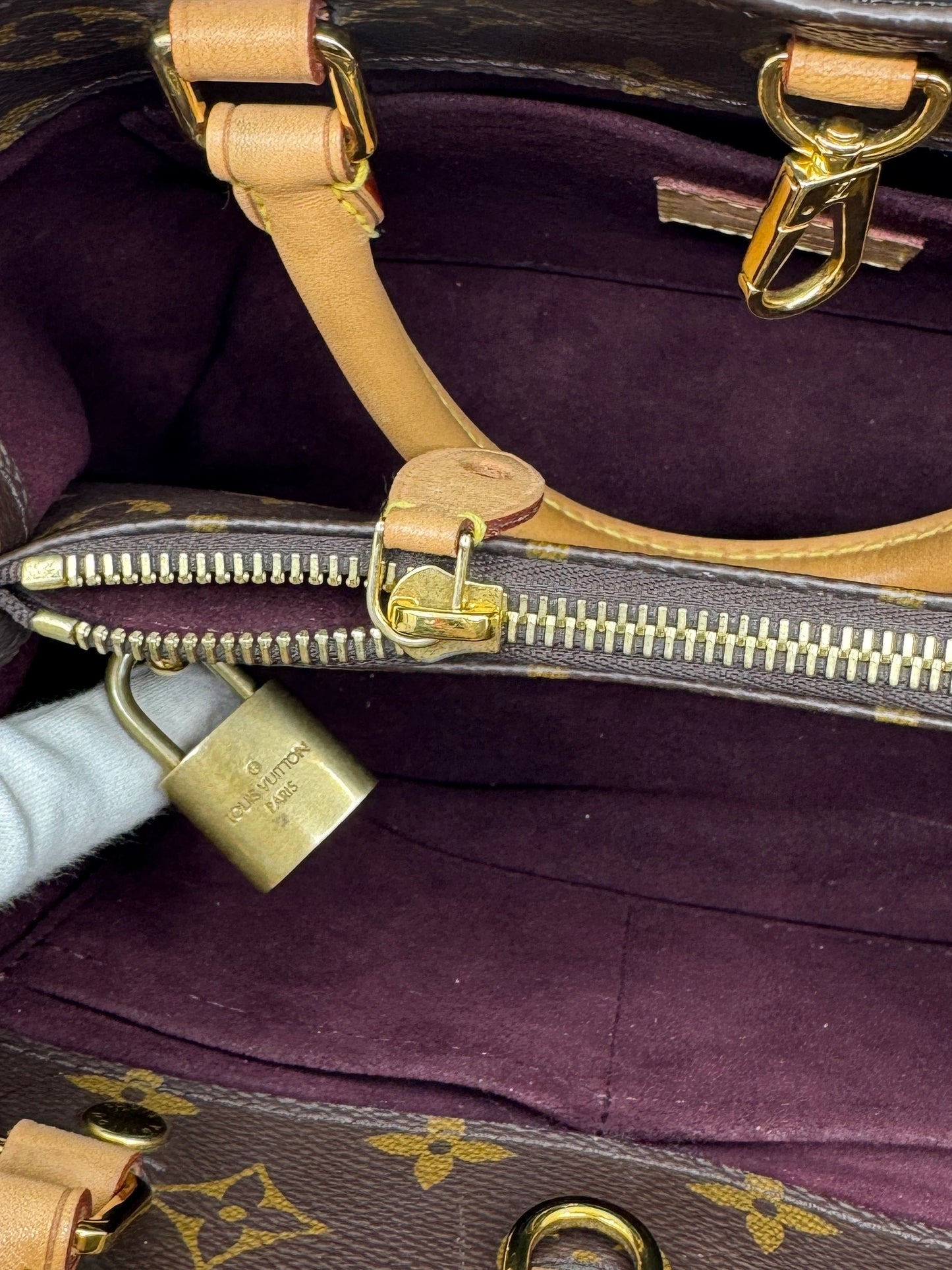 detail-of-interior-of-louis-vuitton-montaigne-bb-bag-with-golden-closure-and-lock-with-registered-louis-vuitton-logo