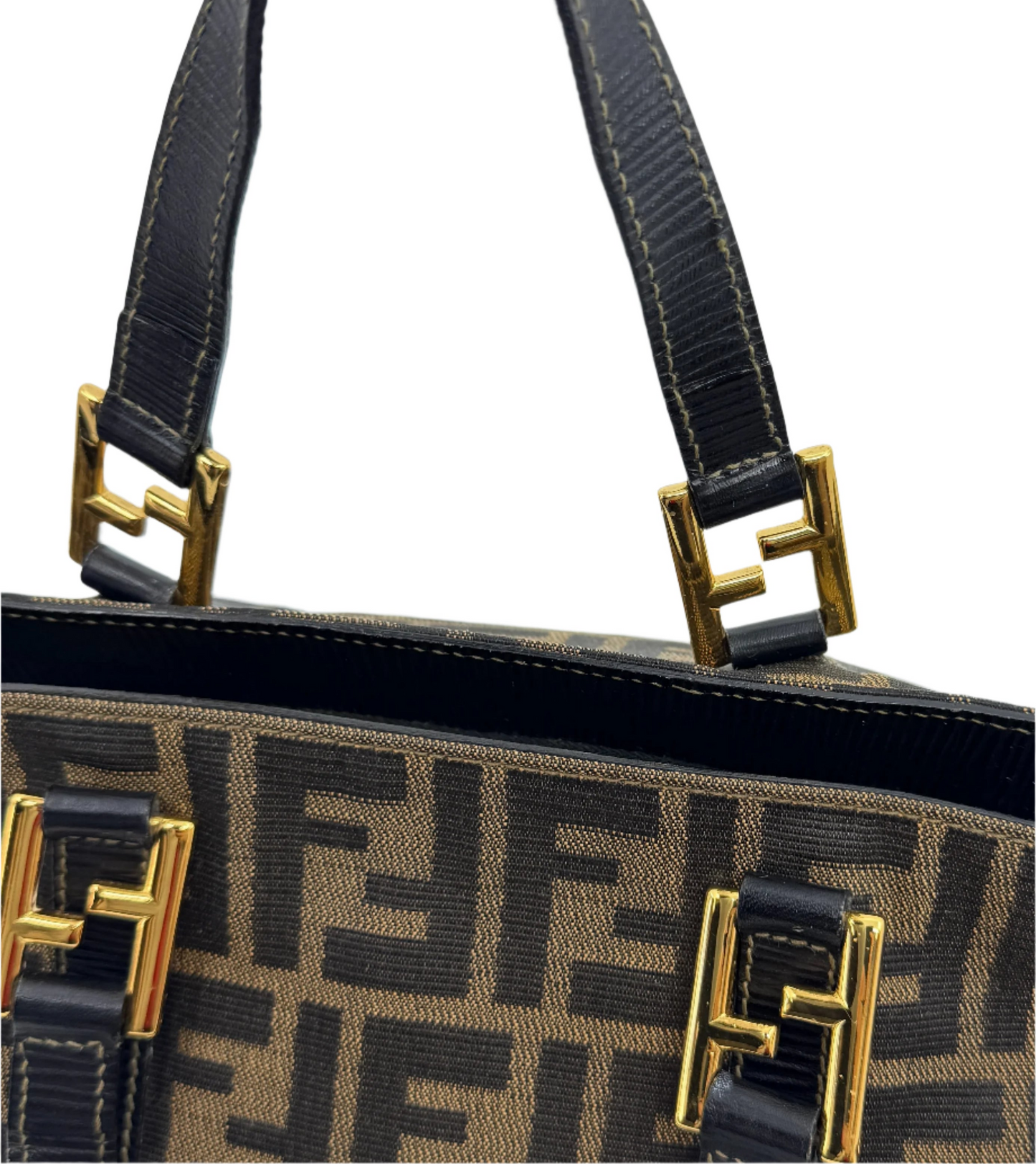 detail-of-the-black-leather-handle-of-the-fendi-zucca-handbag-with-golden-stitching-finishes-focused-on-the-buckle-connecting-the-handles-featuring-the-iconic-ff-logo-in-gold