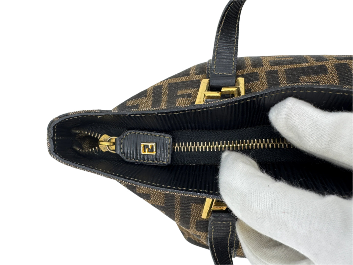 detail-of-the-golden-zipper-of-the-fendi-zucca-handbag-with-ff-logo-golden-hardware-under-the-black-leather-of-the-zipper