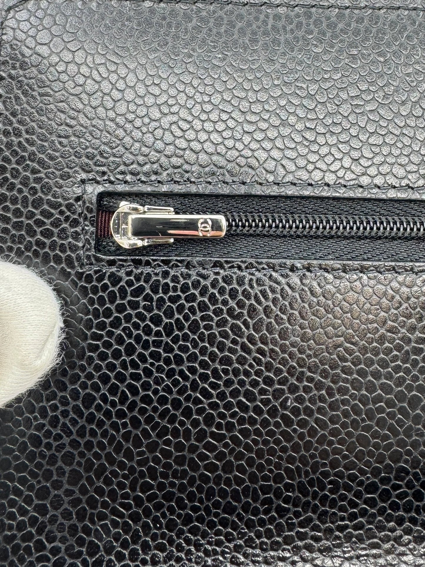 detail-of-the-zipper-of-the-chanel-wallet-on-chain-silver-bag-in-silver-with-cc-logo-studded