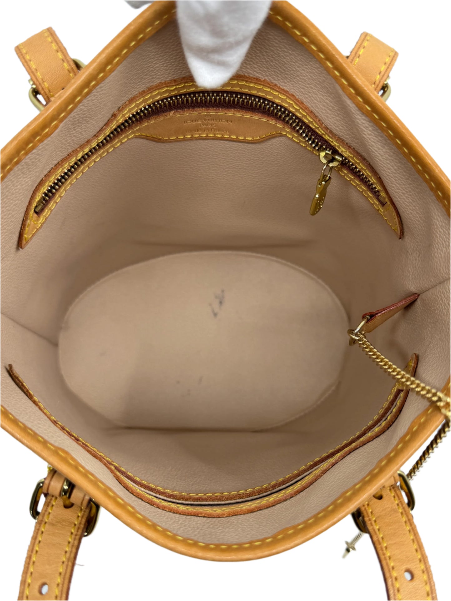 interior-of-louis-vuitton-monogram-petit-bucket-bag-showing-main-round-compartment-and-bottom-with-detail-of-golden-interior-closure-and-vachetta-finishing