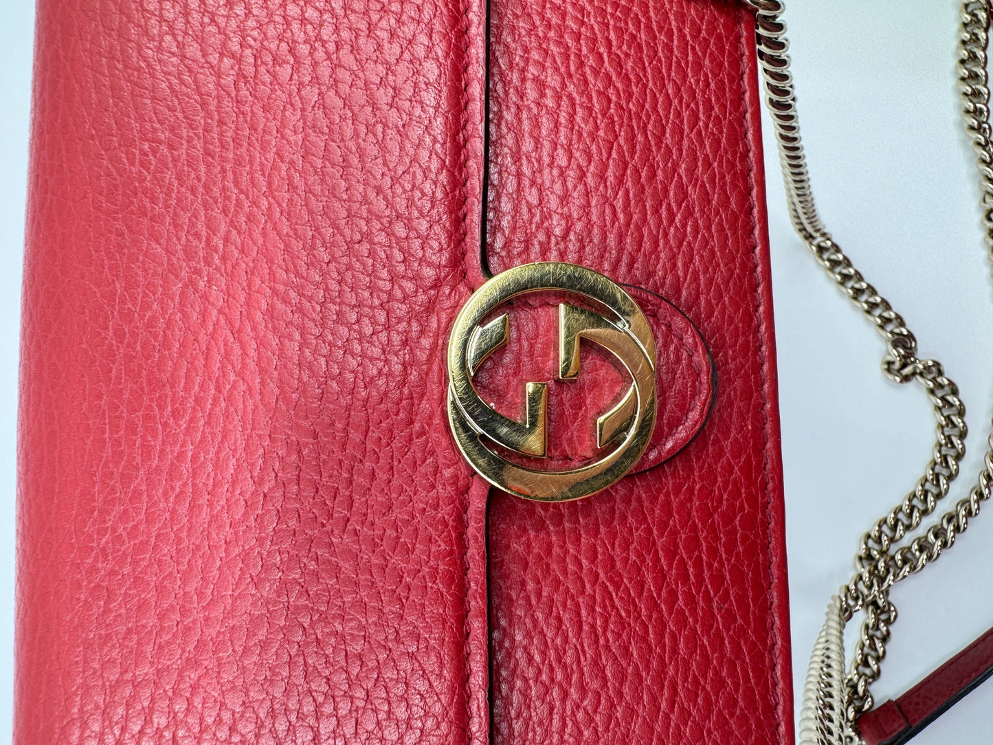 zoom-in-of-the-gold-interlocking-g-closure-of-the-gucci-dollar-calfskin-interlocking-g-chain-wallet