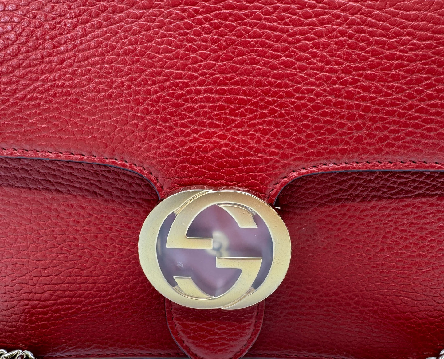 zoom-in-of-the-gold-interlocking-g-logo-on-the-gucci-small-dollar-interlocking-g-red