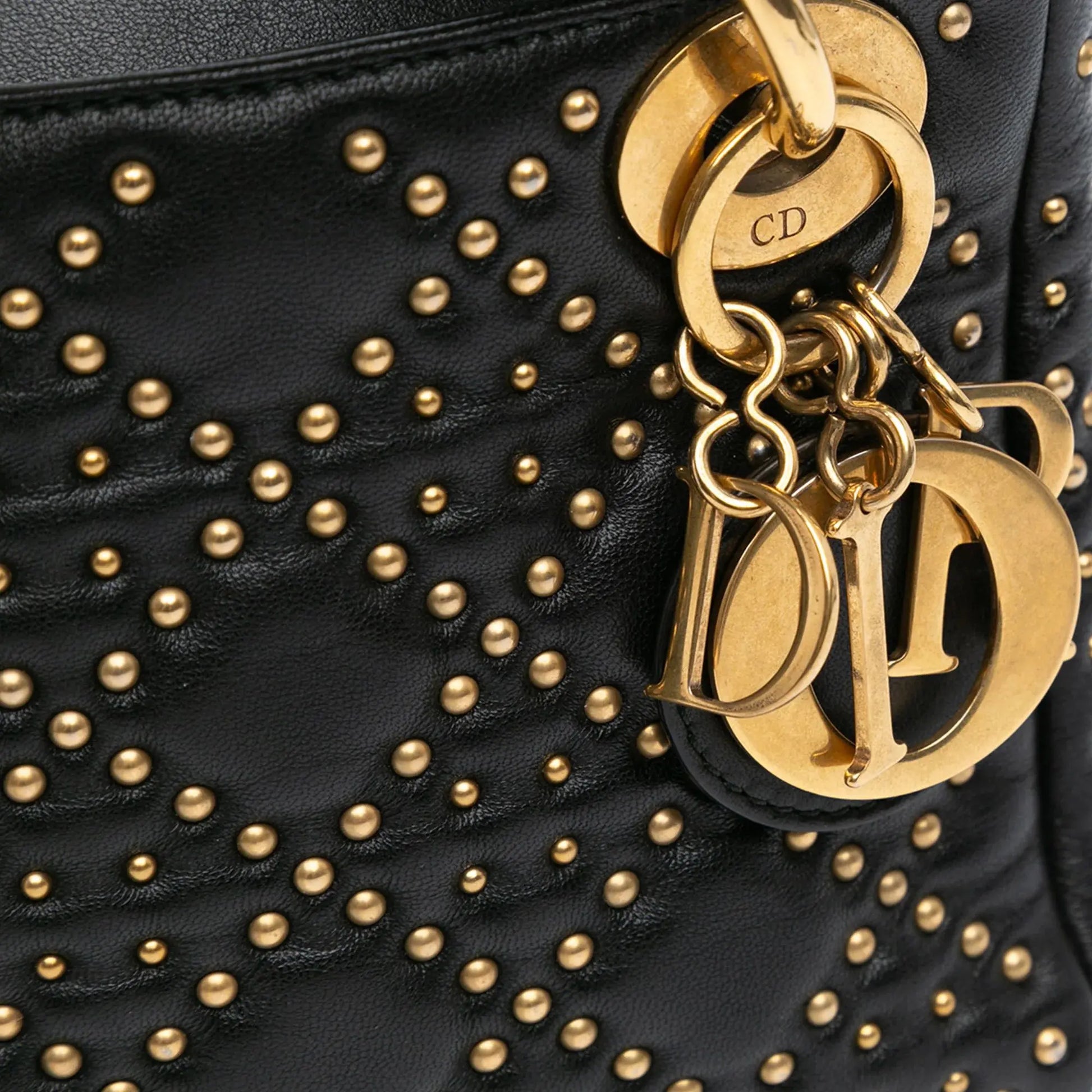 Close-up-details-of-the-gold-tone-Dior-lettering-on-the-Mini-Lady-Dior-Black-Studded-Supple-Cannage-Calfskin.