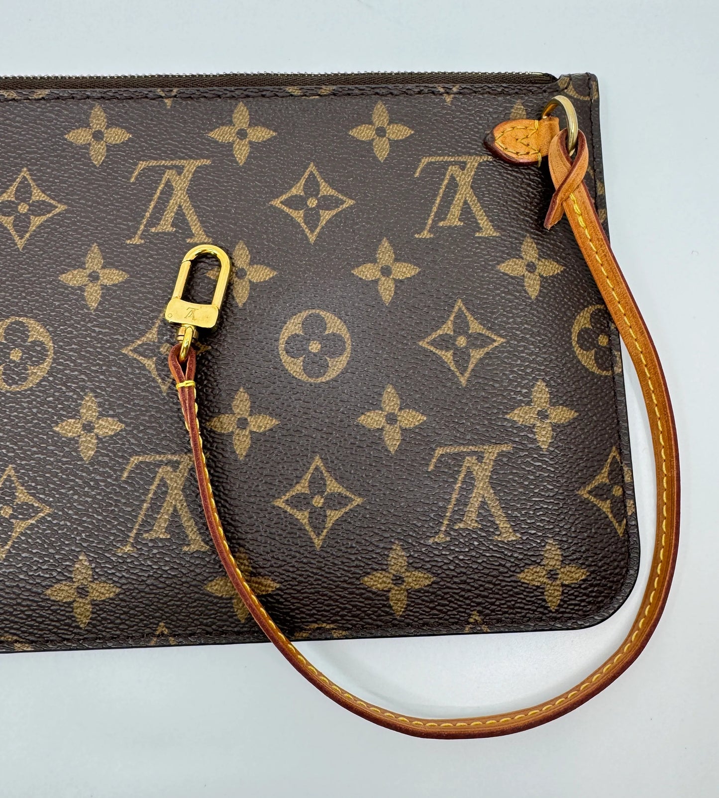 Zoom-in-on-the-front-part-of-the-Louis-Vuitton-Neverfull-MM-Monogram-Pochette-including-logo-across-the-bag-with-details-of-the-closure-and-strap