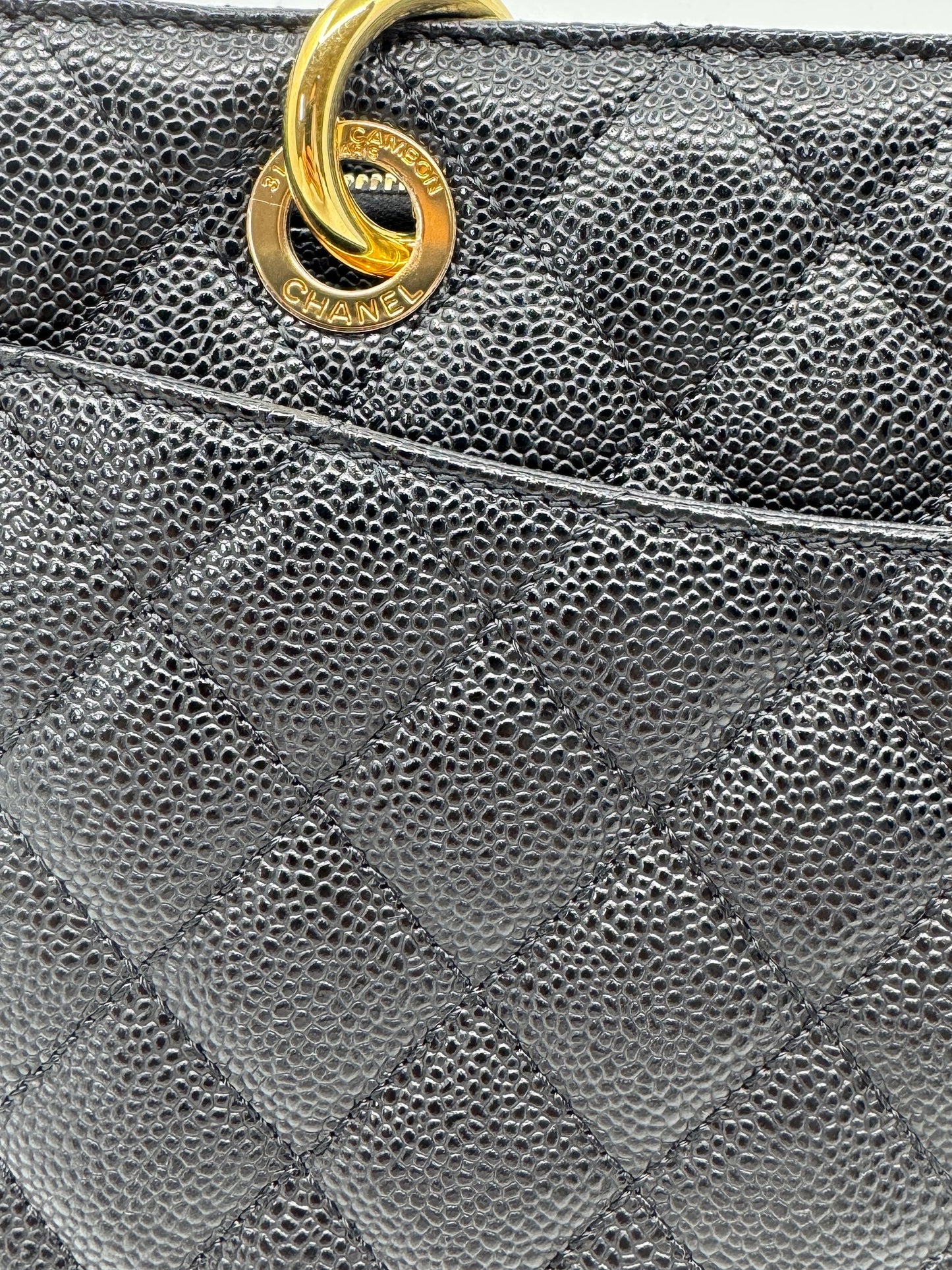 detail-of-golden-ring-on-strap-of-chanel-black-caviar-grand-shopping-tote-with-engraved-chanel-logo