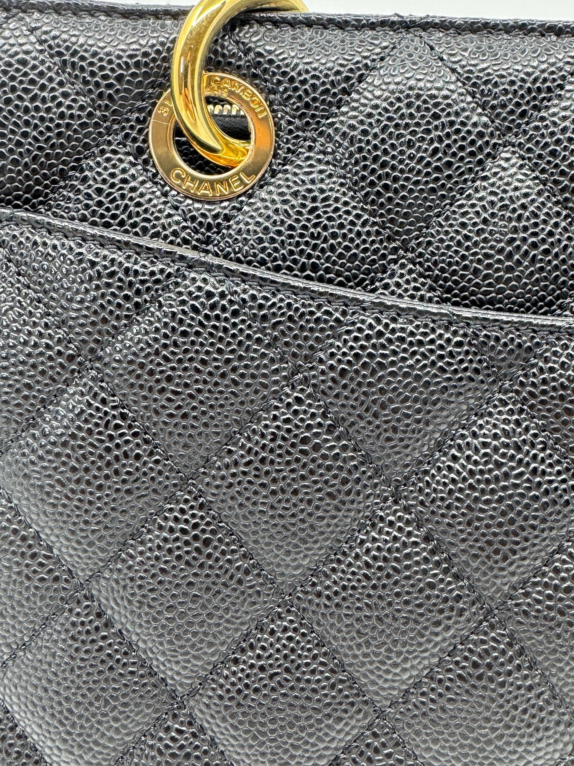 detail-of-golden-ring-on-strap-of-chanel-black-caviar-grand-shopping-tote-with-engraved-chanel-logo