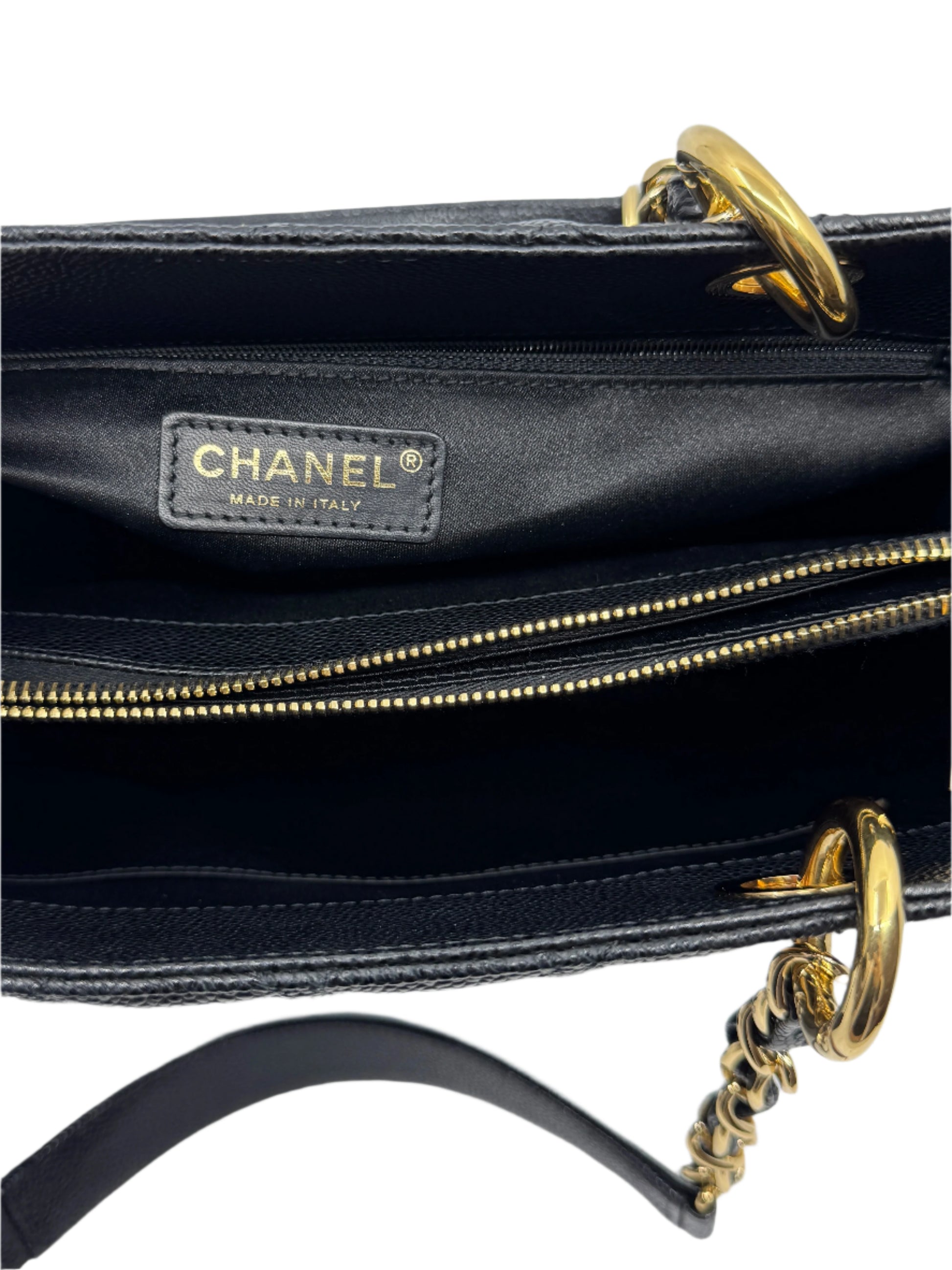 detail-of-interior-of-chanel-black-caviar-grand-shopping-tote-with-golden-zippered-compartments-and-chanel-authenticity-label