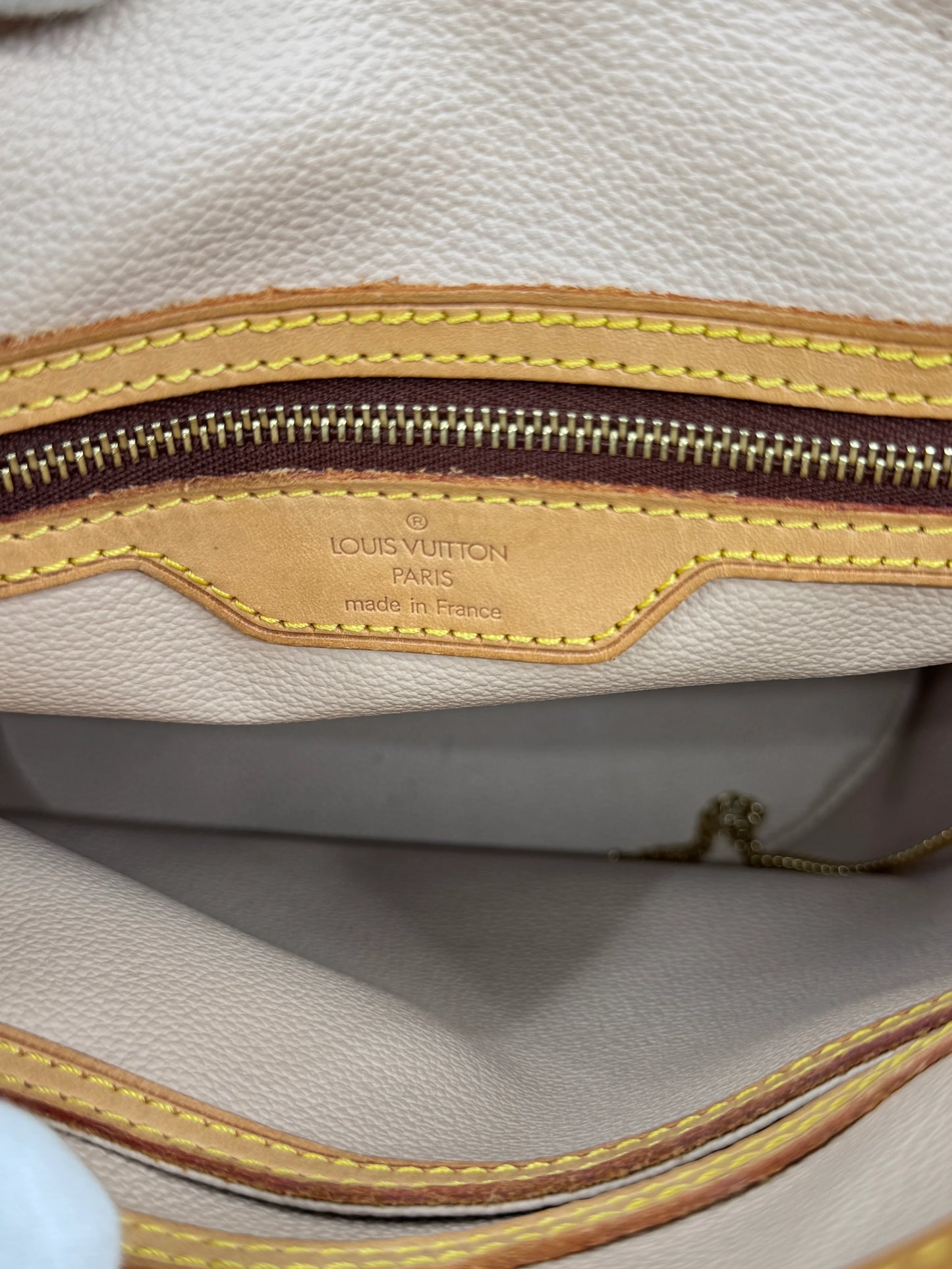 interior-of-golden-closure-of-louis-vuitton-monogram-petit-bucket-bag-with-authenticity-tag-and-made-in-france-label