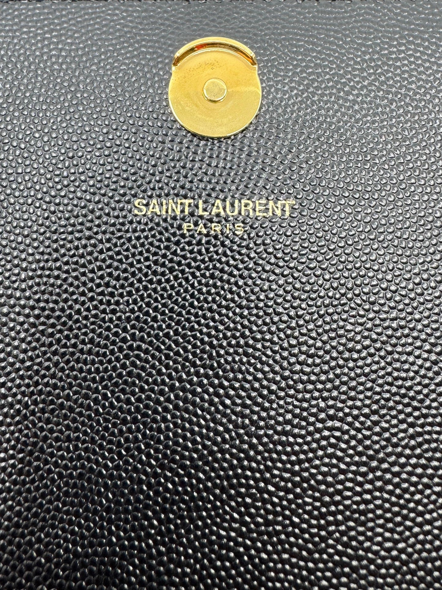 top-of-closure-button-of-Kate-Medium-in-Grain-de-Poudre-Embossed-Leather-in-gold-with-Saint-Laurent-logo-engraved-and-made-in-Paris